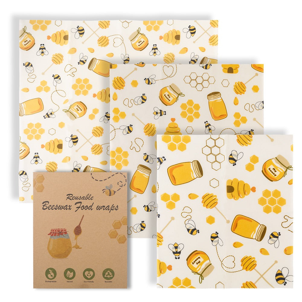 Set of reusable beeswax food wraps with honey and bee pattern on a white background