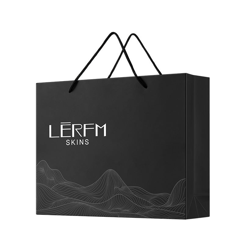 Black paper bag with branding on a white background